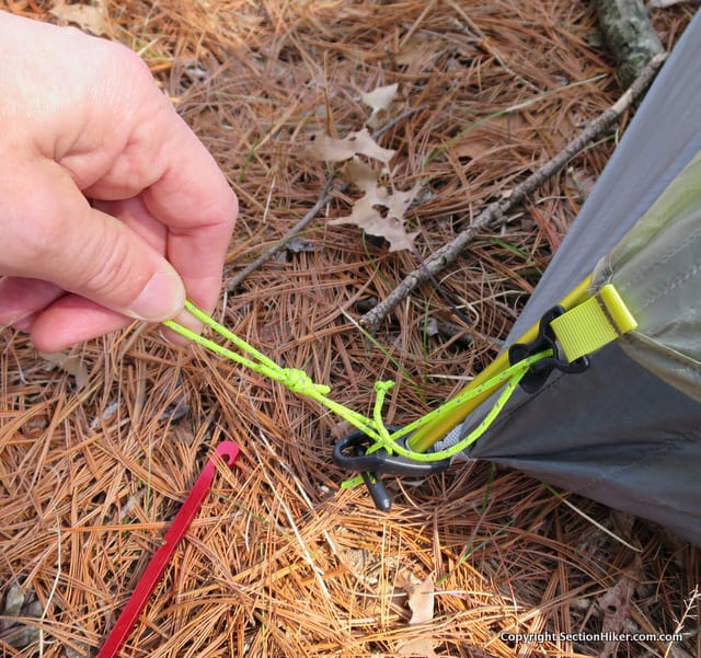 The Rain Fly connects to the corners of the inner tent, only requiring one stake to hold down. Lineloc adjusters are provided to increase the tention of the rain fly. The tent stakes provided with the tent are pretty lame and that's my MSR needle stake which is perfect for securing a cord-based guyline like this .