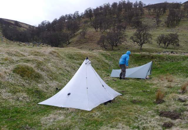 Two tents protected from the wind by a small embankment