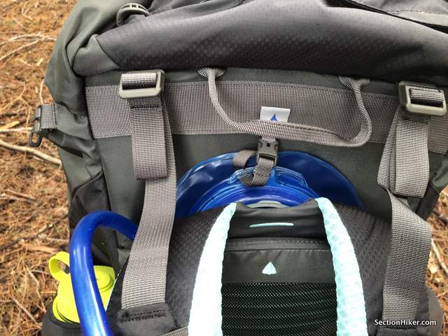 The hydration pocket is located right behind the adjustable length (torso) shoulder straps