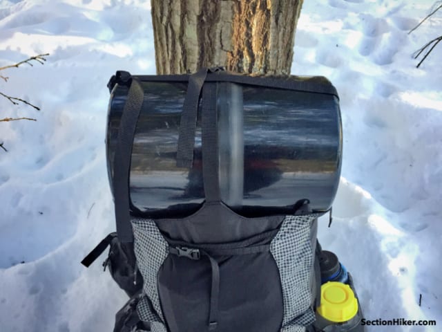 Two very long webbing straps, one front-to-back, and one side-to-side create a small pocket to hold a bear canister, even if you don't use the floating lid. 