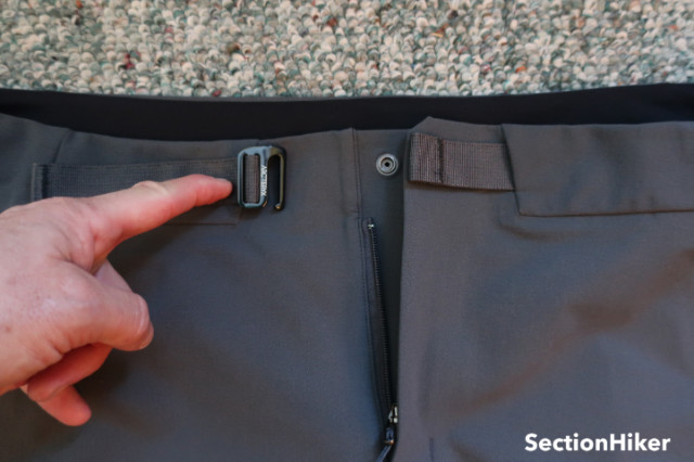 The belt is buried except in front, where it closes with a hook. This makes it much more comfortable under a backpack hip belt strap and you never have to search for a belt. 