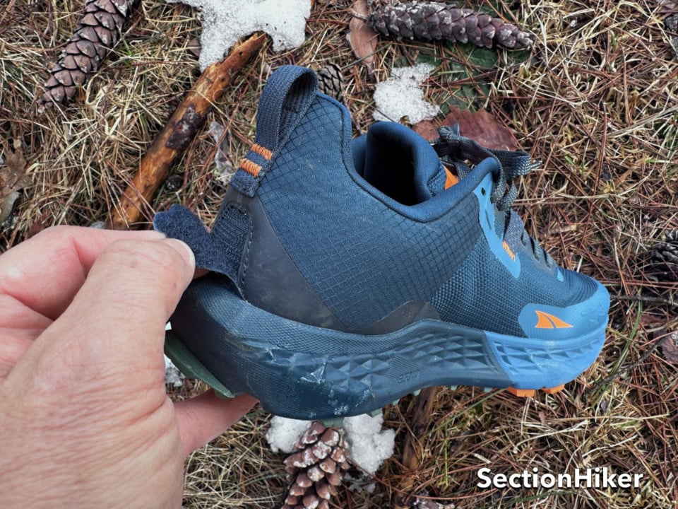 The Timp (and all Altras) have a gaiter trap behind the heel to secure a gaiter.