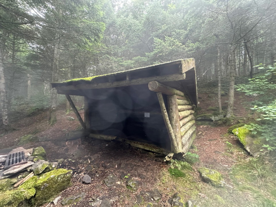 A placa dentro deste abrigo diz: “Aviso: este abrigo não é estruturalmente sólido e está fechado para acampamento no momento. Russell Hill Shelter e Tinker Brook Shelter permanecem abertos.”