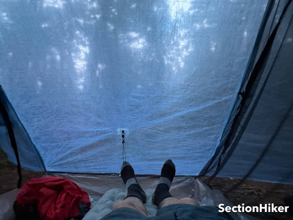 The tent canopy is translucent and provides limited privacy