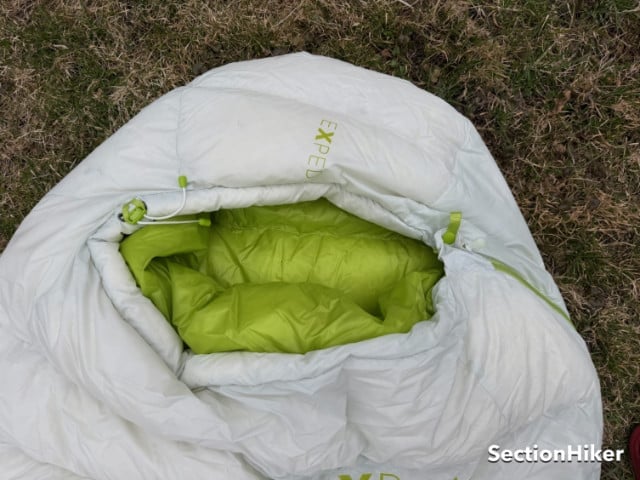 The hood is controlled by a cord lock opposite the zipper